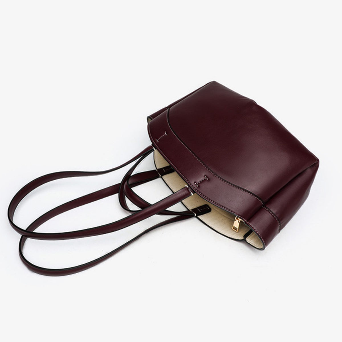 Dark red work tote lying on its side showing the beige lining
